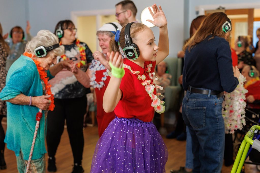 A-child-wearing-headphones-and-dancing-in-a-room-with-other-people