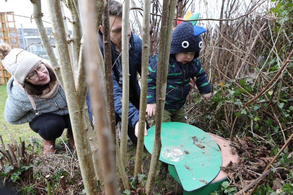 child in forest exploring nature with parents
