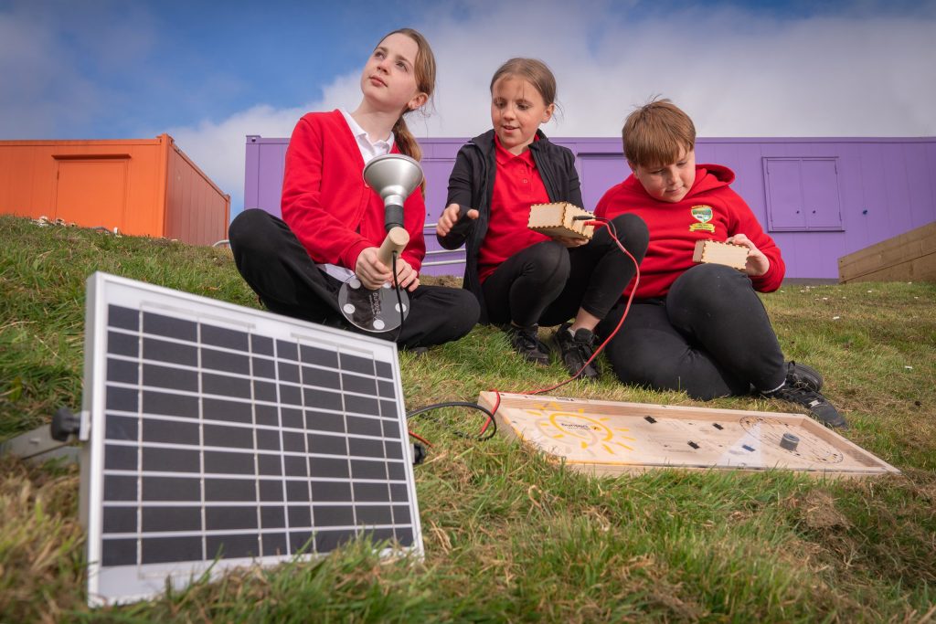 Learners at Garnteg Primary try out the solar panel kit.